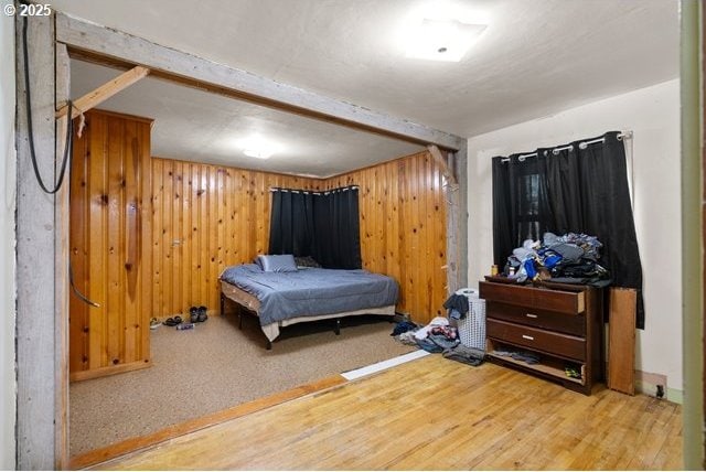 bedroom with wood walls and wood finished floors
