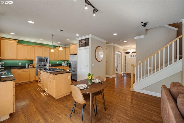 kitchen featuring a notable chandelier, dark countertops, light brown cabinetry, and appliances with stainless steel finishes