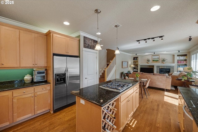 kitchen featuring light wood-style flooring, stainless steel appliances, and a textured ceiling