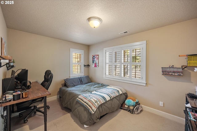 carpeted bedroom with baseboards, a textured ceiling, and visible vents