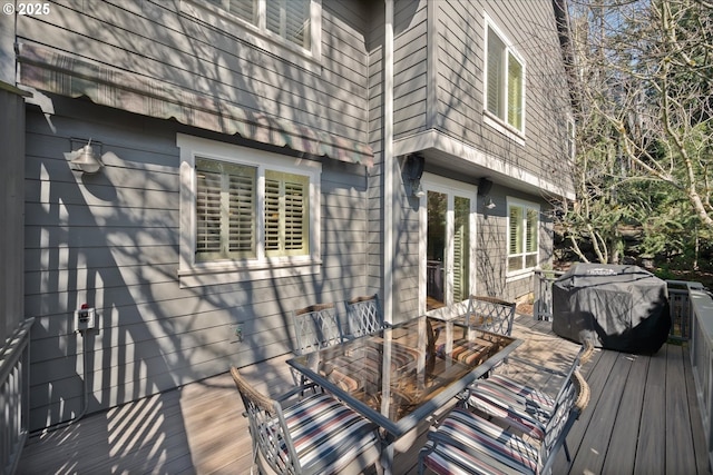 wooden terrace with outdoor dining area and a grill