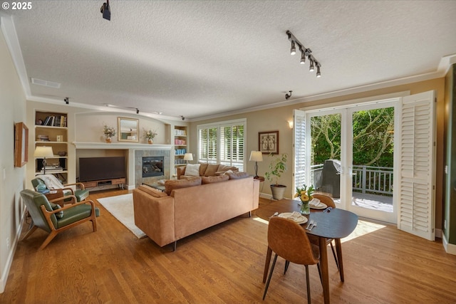 living area with light wood-style flooring, a textured ceiling, and visible vents