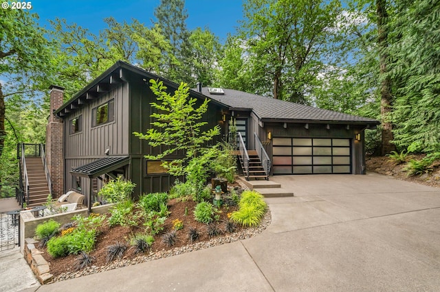 3777 Parkwood Way W, Linn, OR 97068 - view of front of property with stairway, board and batten siding, a chimney, a garage, and concrete driveway