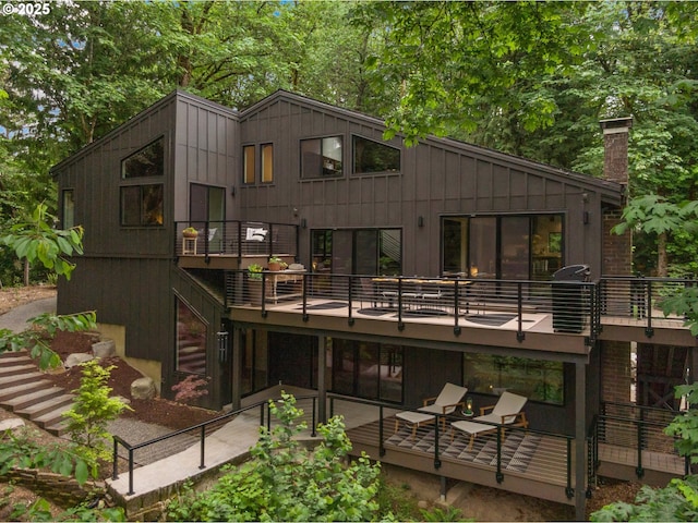 3777 Parkwood Way W, Linn, OR 97068 - rear view of house with a balcony, a chimney, and board and batten siding