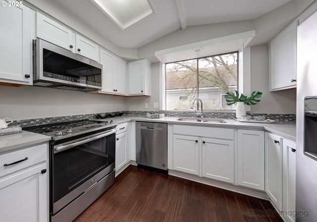 kitchen featuring a sink, dark wood-style floors, appliances with stainless steel finishes, white cabinets, and light countertops