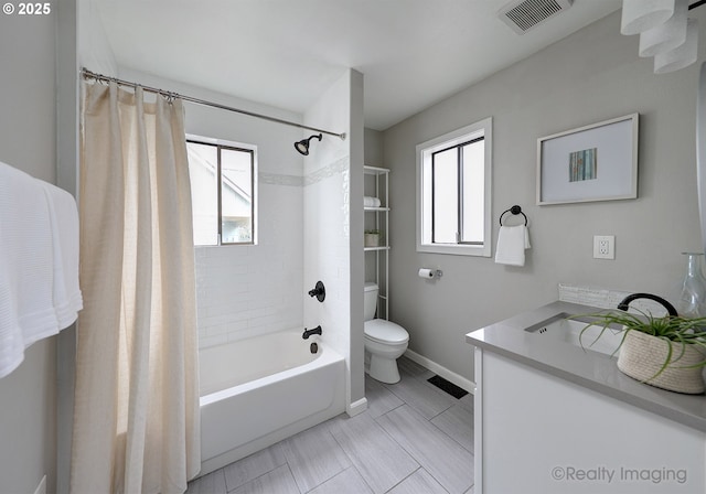 bathroom featuring visible vents, plenty of natural light, toilet, and shower / tub combo with curtain