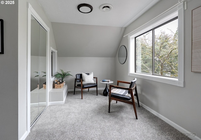 sitting room with carpet flooring, baseboards, and lofted ceiling