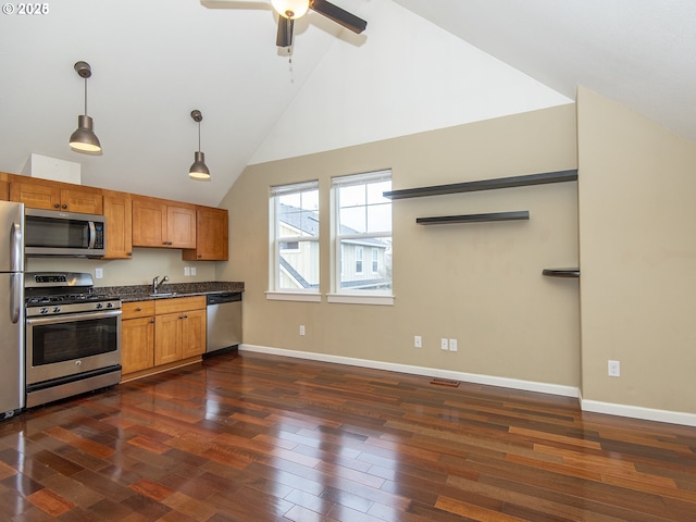 kitchen featuring dark countertops, appliances with stainless steel finishes, dark wood-type flooring, and a ceiling fan