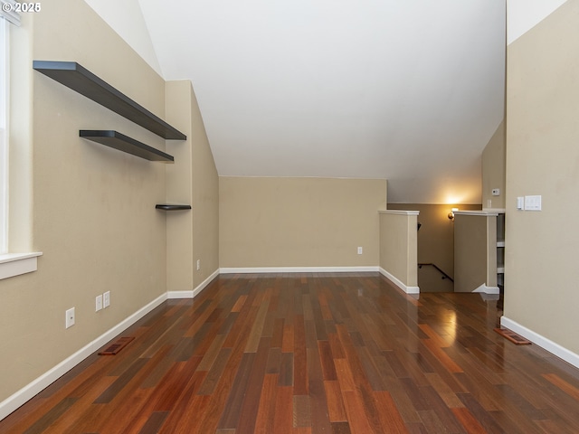 unfurnished living room with lofted ceiling, wood finished floors, visible vents, and baseboards