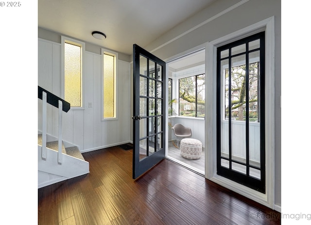 entryway with french doors, wood-type flooring, and stairs