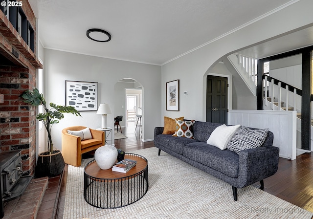 living area with arched walkways, wood finished floors, a wealth of natural light, and ornamental molding