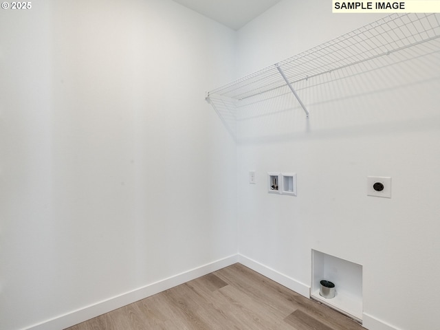 clothes washing area featuring electric dryer hookup, hookup for a washing machine, light wood-style flooring, and baseboards