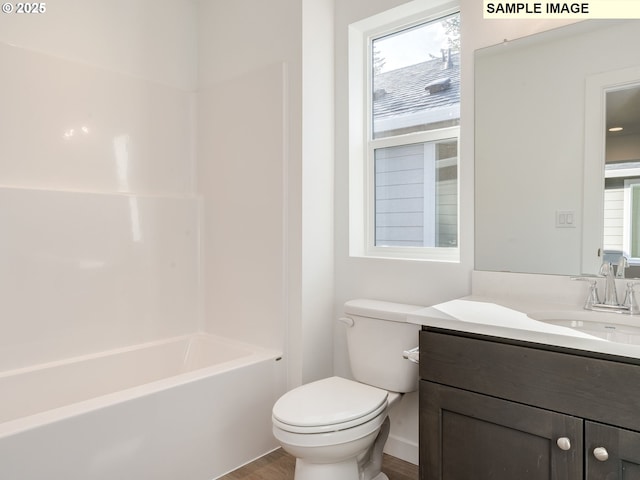 bathroom featuring toilet, wood finished floors, vanity, and shower / tub combination