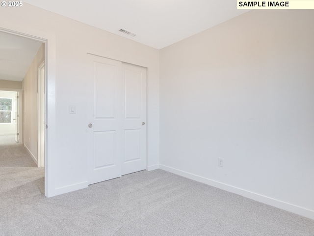 unfurnished bedroom featuring carpet floors, a closet, and baseboards