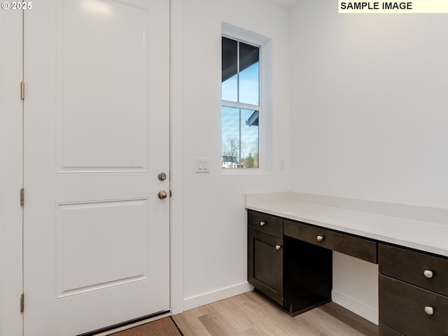 doorway to outside with light wood-type flooring and baseboards