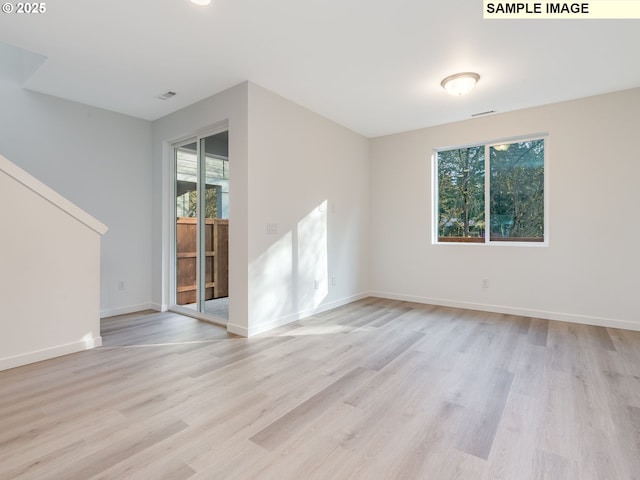 empty room with light wood-type flooring and baseboards