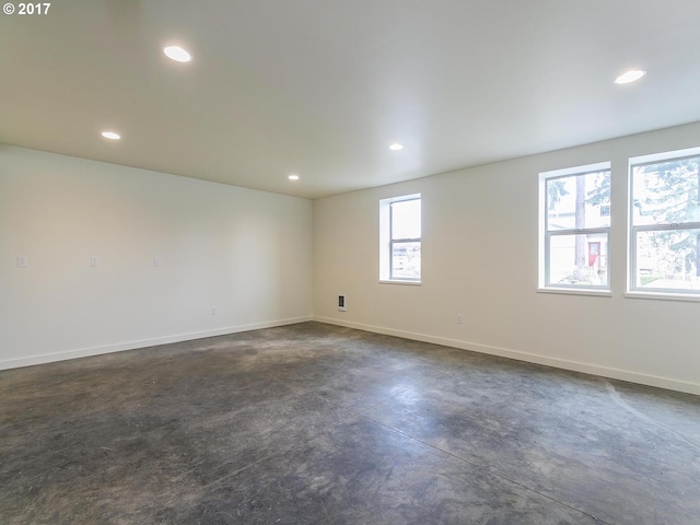 unfurnished room with baseboards, recessed lighting, and finished concrete floors