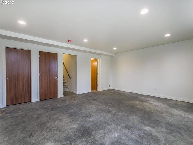 unfurnished bedroom featuring multiple closets, baseboards, concrete flooring, and recessed lighting