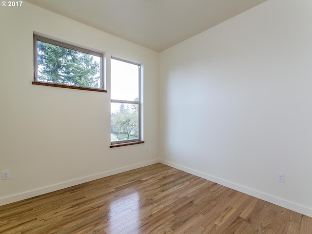 spare room with light wood-style flooring and baseboards