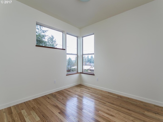 empty room featuring light wood-style flooring and baseboards