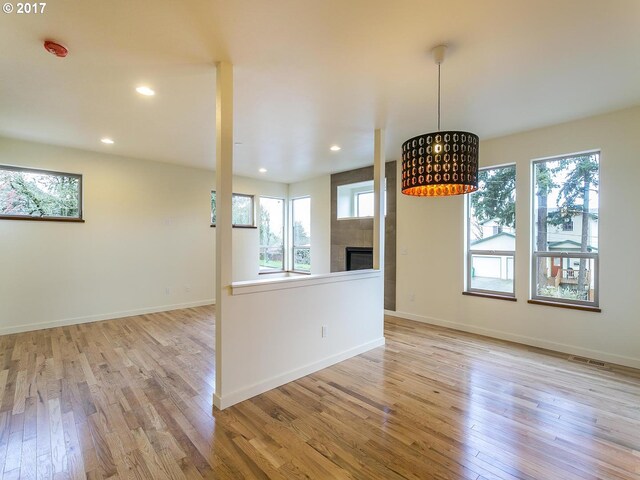 unfurnished room featuring baseboards, a healthy amount of sunlight, and light wood-style floors