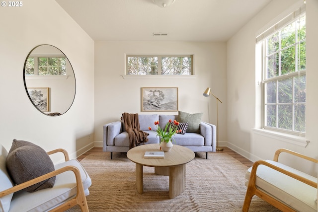 sitting room with visible vents, baseboards, and wood finished floors
