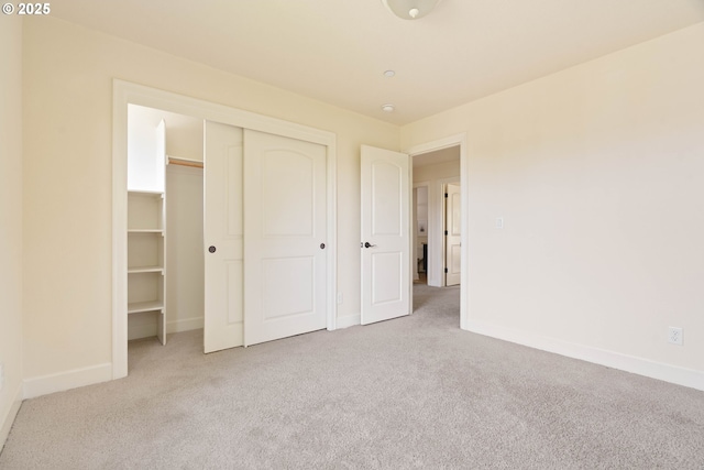 unfurnished bedroom with a closet, baseboards, and carpet