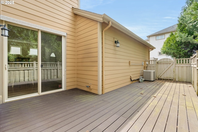 wooden terrace featuring central air condition unit and a gate