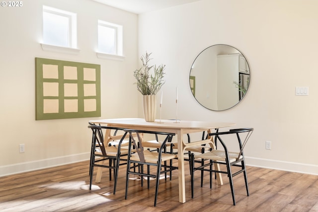 dining room featuring wood finished floors and baseboards