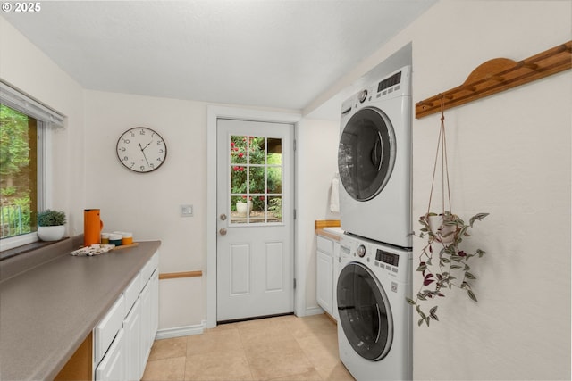 9990 SW Morrison St, Portland, OR 97225 - laundry area with stacked washer / drying machine, cabinet space, light tile patterned flooring, and healthy amount of natural light