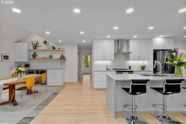 9990 SW Morrison St, Portland, OR 97225 - kitchen featuring wall chimney range hood, a sink, appliances with stainless steel finishes, backsplash, and light countertops