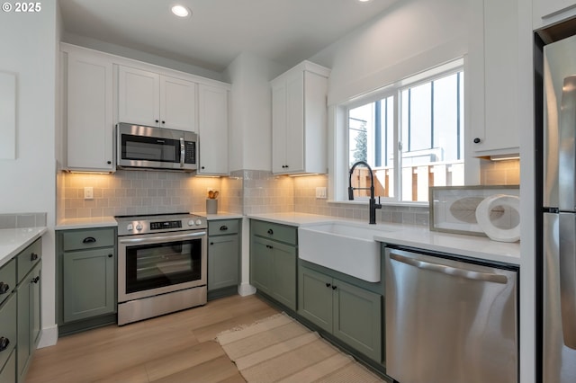 7257 SE Duke St Unit 3, Portland, OR 97206 - kitchen featuring stainless steel appliances, green cabinetry, a sink, light countertops, and recessed lighting