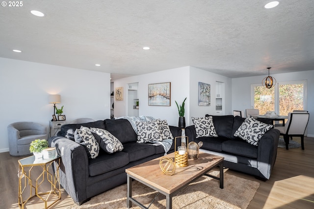 living room featuring a textured ceiling, a notable chandelier, wood finished floors, and recessed lighting