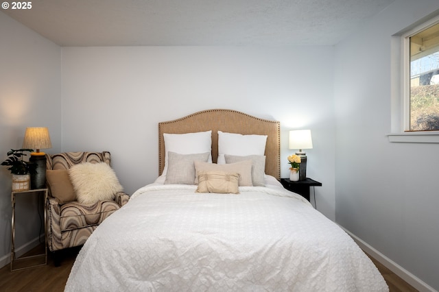 bedroom with dark wood-style floors and baseboards