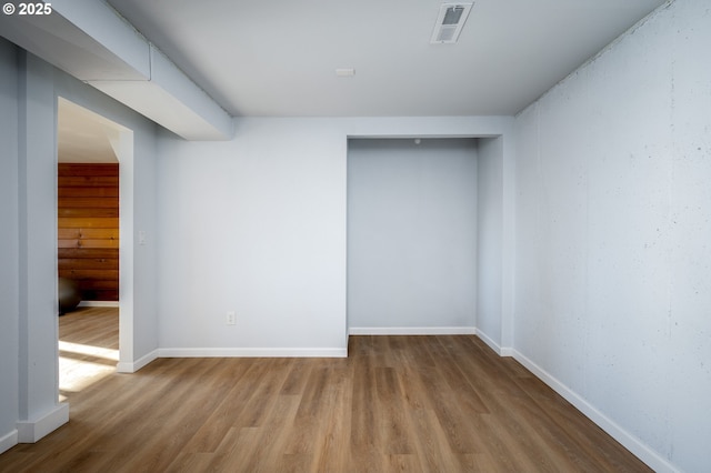 interior space with stairway, baseboards, visible vents, and wood finished floors