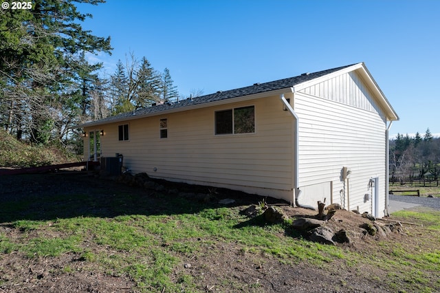 view of property exterior with a yard, central AC unit, and board and batten siding