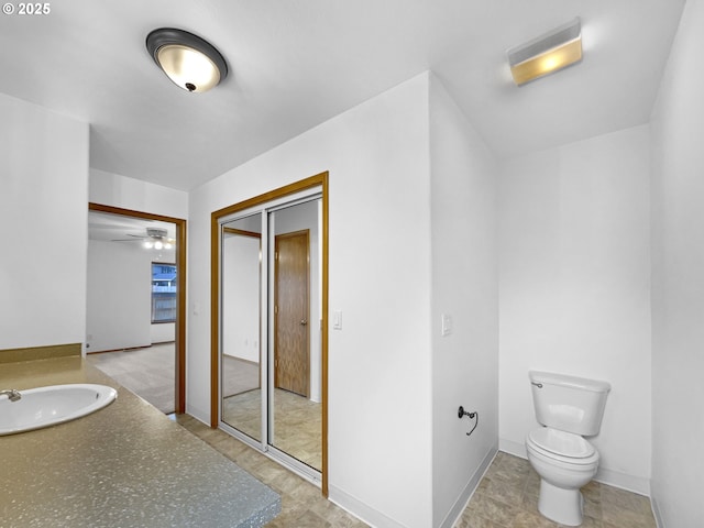 bathroom with a sink, toilet, and baseboards