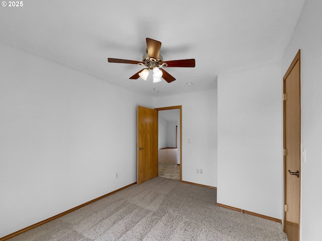 empty room featuring baseboards, a ceiling fan, and light colored carpet