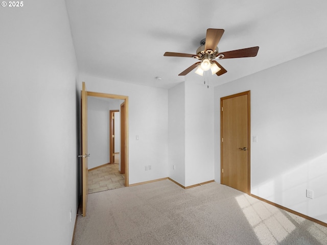 unfurnished room with baseboards, a ceiling fan, and light colored carpet