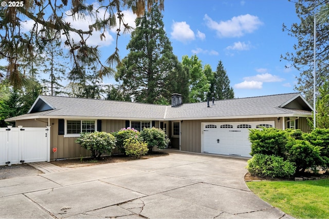 ranch-style home with board and batten siding, driveway, a chimney, a gate, and a garage