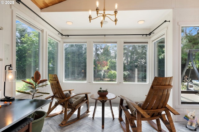 sunroom / solarium with a chandelier and lofted ceiling