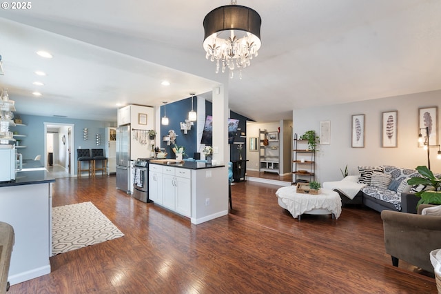 living room featuring dark wood-type flooring, recessed lighting, and a notable chandelier