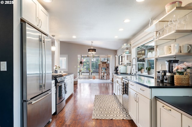 kitchen featuring stainless steel appliances, dark countertops, dark wood-style floors, and a wealth of natural light
