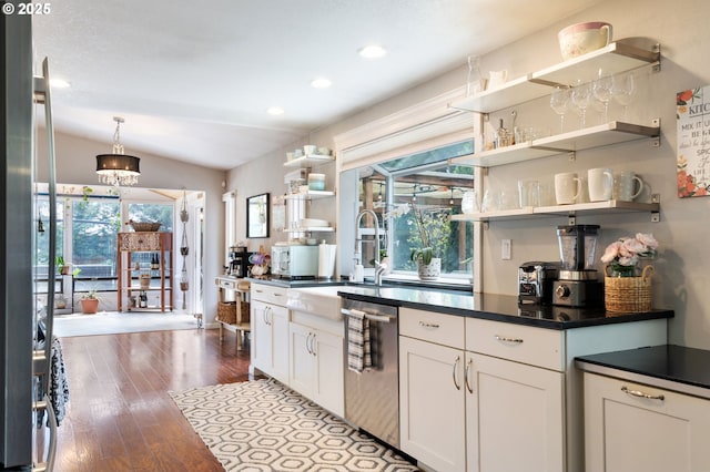 kitchen featuring dark countertops, stainless steel dishwasher, open shelves, vaulted ceiling, and wood finished floors