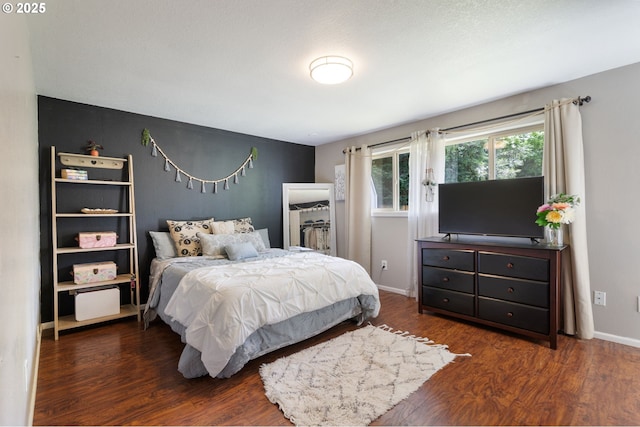 bedroom with baseboards and wood finished floors