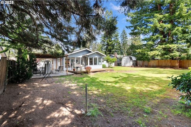 view of yard with a fenced backyard, a storage unit, an outdoor structure, and a patio