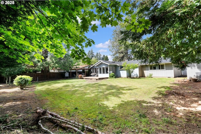view of yard with a sunroom and a fenced backyard