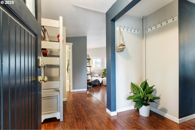 hall with baseboards and wood finished floors