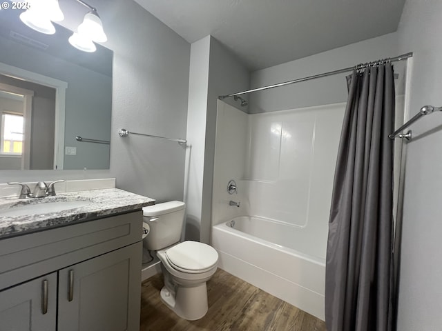 bathroom with wood finished floors, vanity, shower / bath combo with shower curtain, toilet, and visible vents