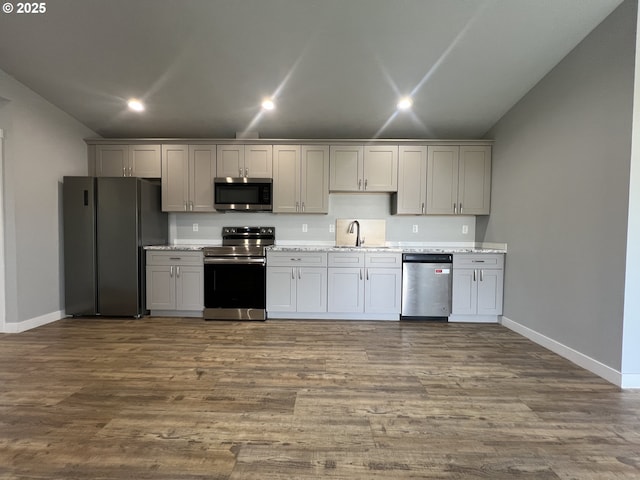 kitchen featuring recessed lighting, appliances with stainless steel finishes, baseboards, and a sink